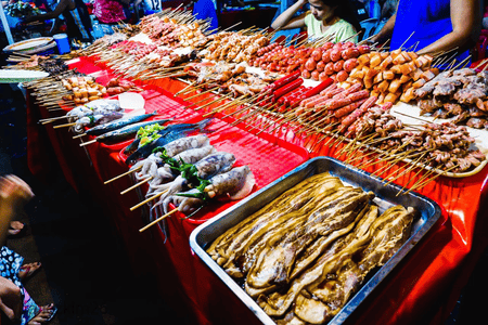 A table full of seafood, meat and street food in skewers ready for grilling