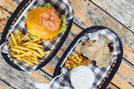 Burger with fries on the side and a burger steak with rice and mixed veggies