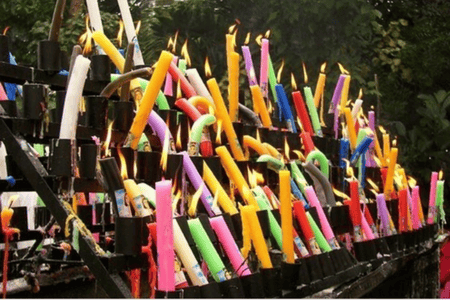 Lit candles with different colors offered by devotees
