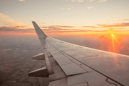 photo of an aircraft wing with the sunset
