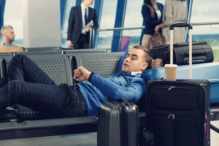passenger at an airport looking at his watch