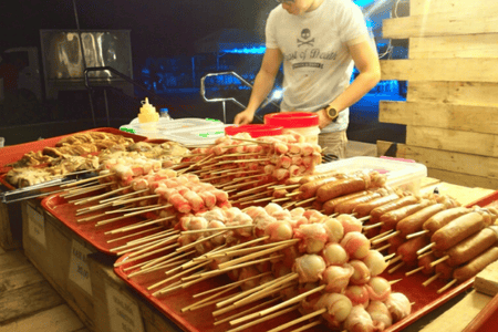 Trays of meat and street food in skewers ready for grilling