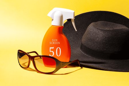 Hat, sunglasses, and a bottle of sunscreen