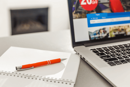 blank notepad and pen beside a laptop