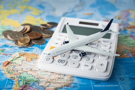 toy plane on a calculator with world map in background