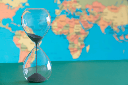 an hourglass with world map on the background