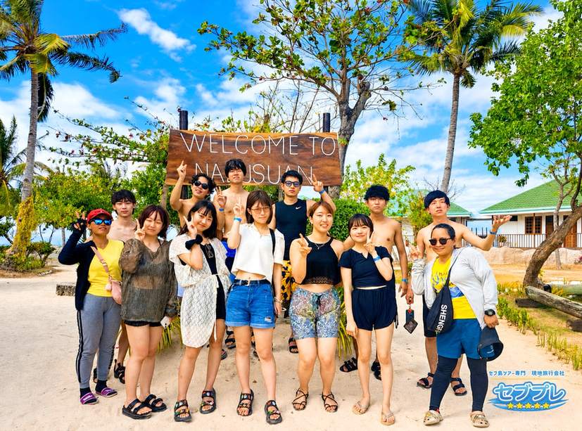 ナルスアン島の看板前での団体集合写真